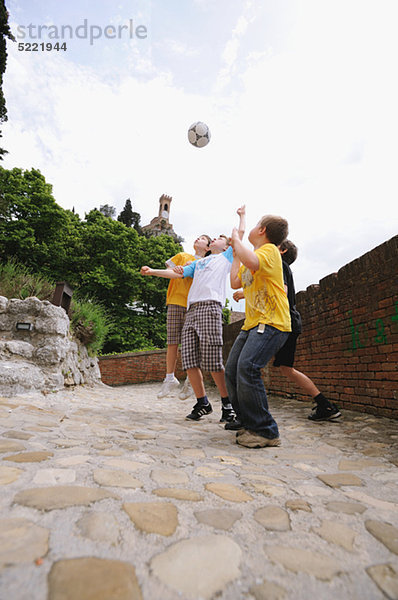 Jungs spielen Fußball In Street