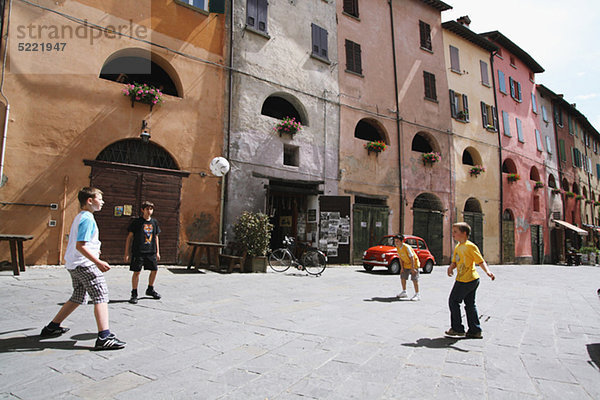 Jungs spielen Fußball In Street