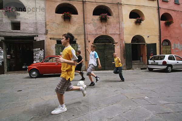 Jungen  die mit Soccer Ball In Street