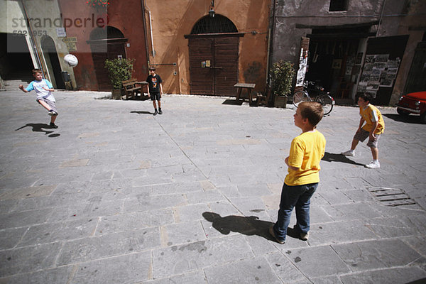 Jungs spielen Fußball In Street