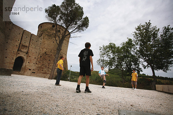 Jungs spielen Fußball an Burg Fort