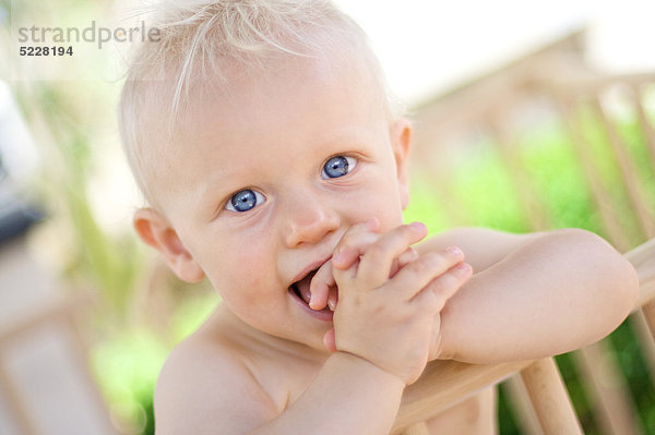 Kleiner blonder Junge mit der Hand im Mund  Portrait