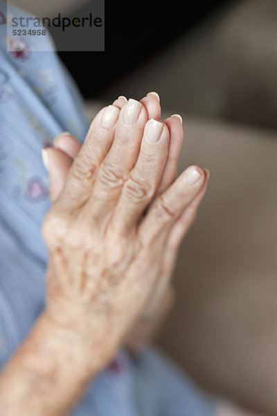 Detail einer älteren Frau beim Beten