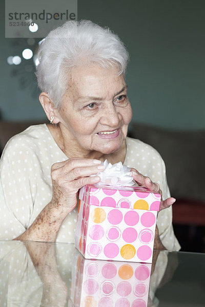 Porträt einer älteren Frau mit einem Geschenk