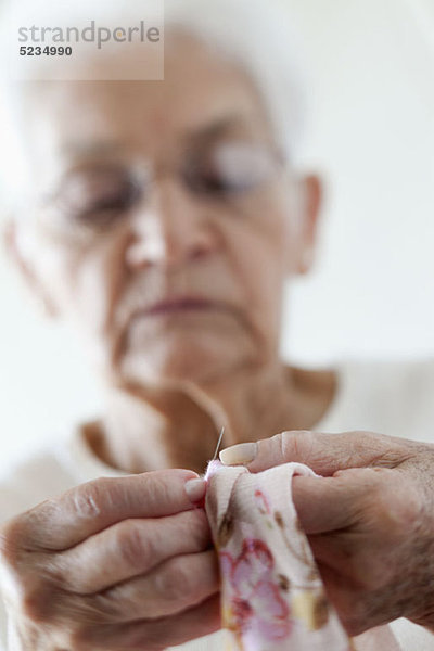 Detail eines Senioren-Frauen-Stickerei-Stoffes
