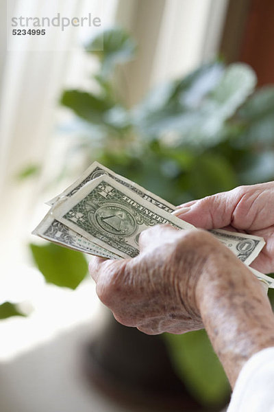 Detail einer älteren Frau mit US-Banknoten