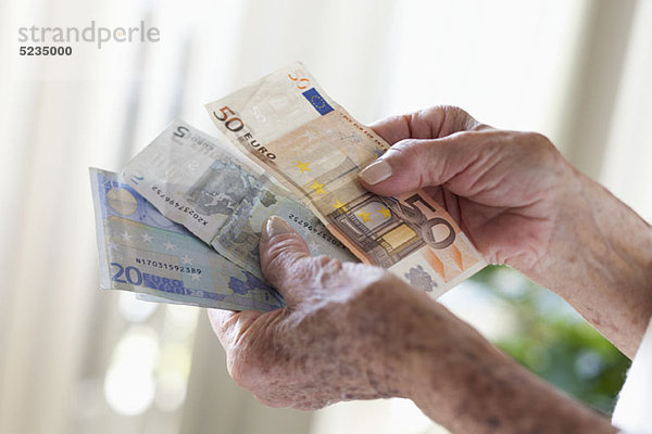 Detail einer älteren Frau mit europäischen Banknoten