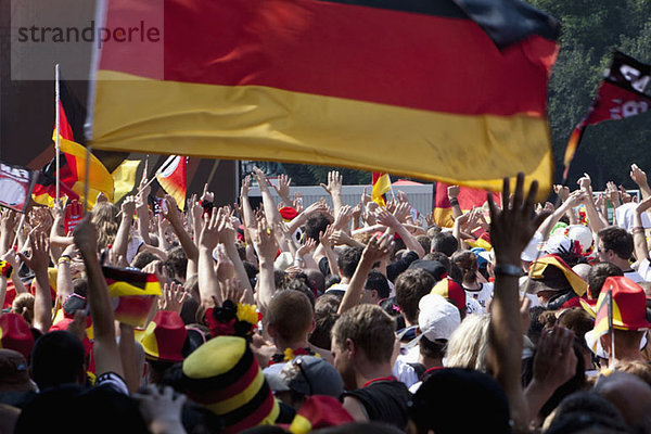 Detail der Menschen in einer Menschenmenge  die jubelnd und mit deutschen Flaggen wedelt