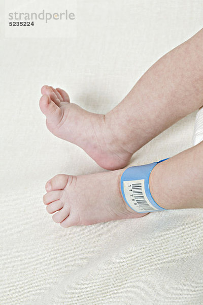 Ein Krankenhaus-Ausweis-Armband am Knöchel eines Babys.