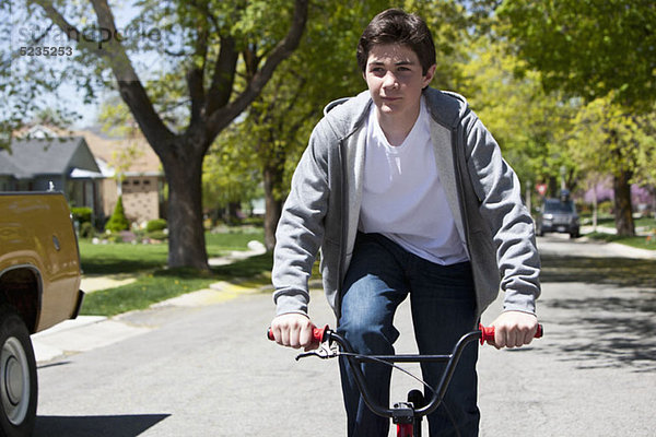 Junge steht beim Radfahren mit einem zufriedenen Gesichtsausdruck