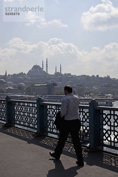 Ein Geschäftsmann  der über die Galata-Brücke geht  Istanbul  Türkei