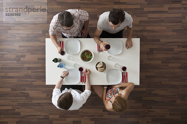 Zwei Freunde beim Trinken auf einer Dinnerparty  Blick über den Kopf