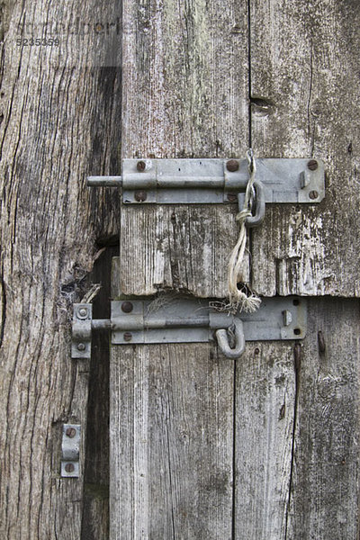Zwei Schiebeverschlüsse an einer verzogenen Holztür