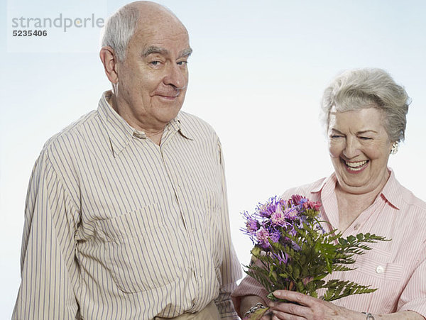 Der ältere Mann weiß  dass sie glücklich ist  wenn er ihr Blumen schenkt.