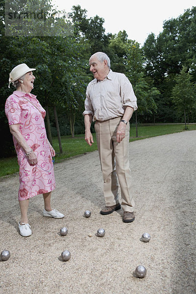Senior Mann und Frau spielen Boules im Park.