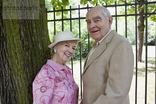 Seniorenpaar im Park lächelt vor der Kamera