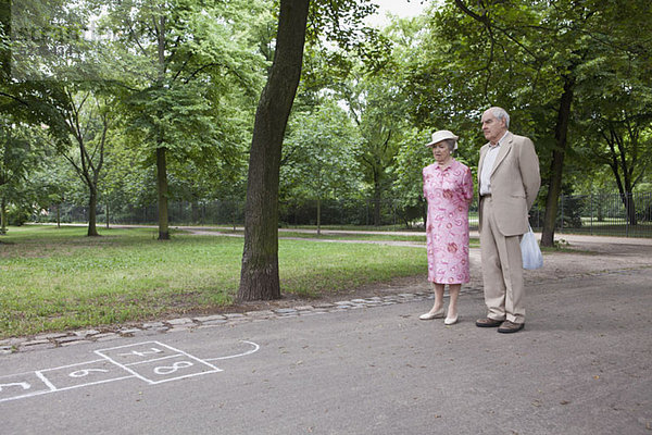 Seniorenpaar erwägt Hopscotch im Park