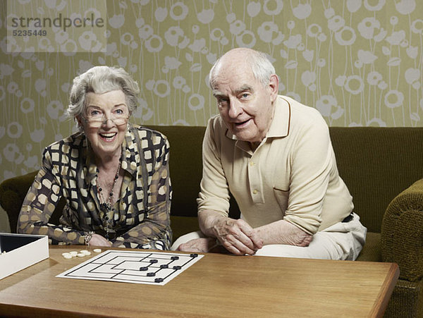Senior Mann und Frau spielen Mühle auf der Couch