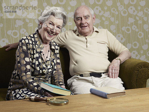 Senior Mann und Frau mit Büchern auf der Couch