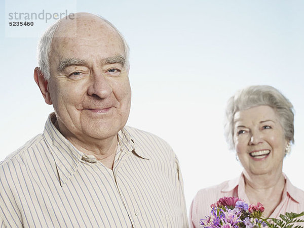 Der ältere Mann freut sich  dass sie die Blumen mag.