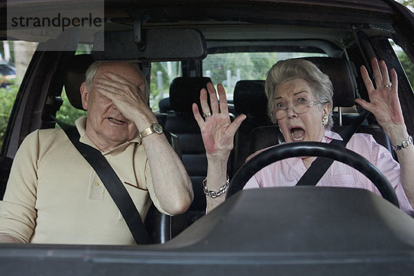 Ältere Frau  die Schwierigkeiten hat  als Mann auf dem Beifahrersitz zu fahren.