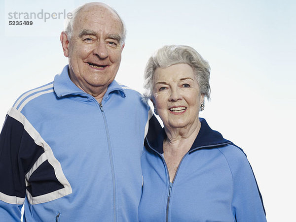 Senior Mann und Frau in Sportbekleidung lächelnd vor der Kamera