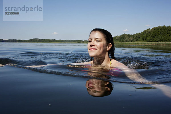 Mädchen schwimmt fröhlich im See