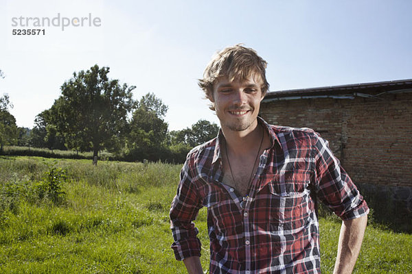 Kerl im Feld mit Scheune im Hintergrund