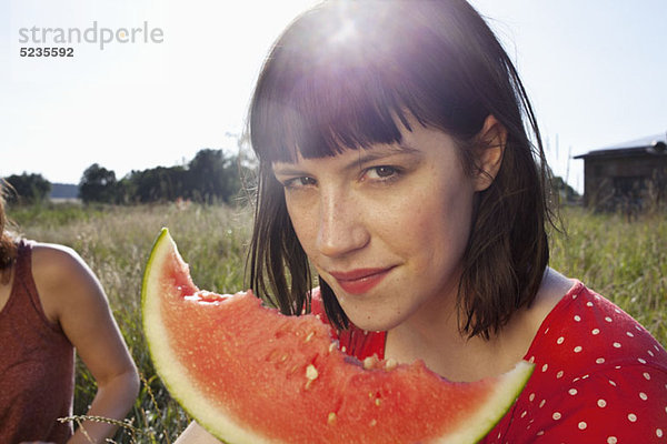 Mädchen hat ein Stück Melone in der Hand mit Fahrradmarkierungen.