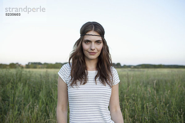 Profil des Mädchens mit Haarband im abgelegenen Feld stehend