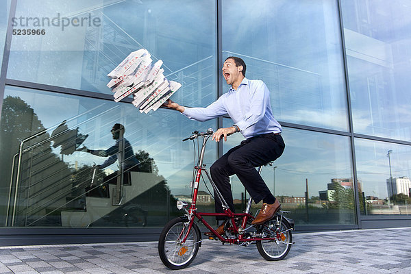 Mann mit Pizzakartons auf dem Fahrrad