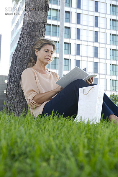 Frau im Gras sitzend Lesebuch