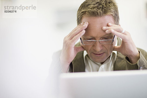 Gestresster Geschäftsmann bei der Arbeit im Büro