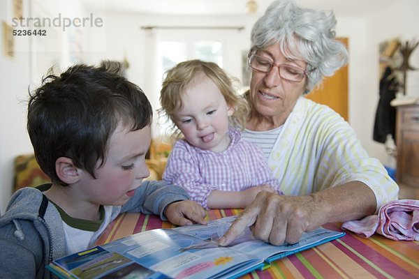 Großmutter Lesebuch mit jungen Enkelkindern