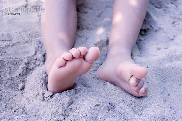 Beine des kleinen Mädchens im Sand  niedrige Sektion