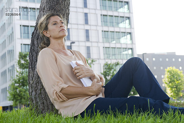 Frau im Gras sitzend  packendes Buch