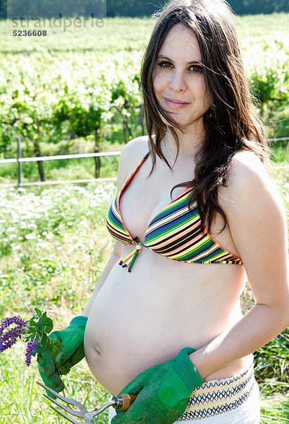 Schwangere Frau im Garten im Freien