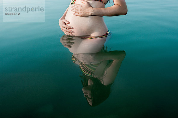 Schwangere Frau im See stehend