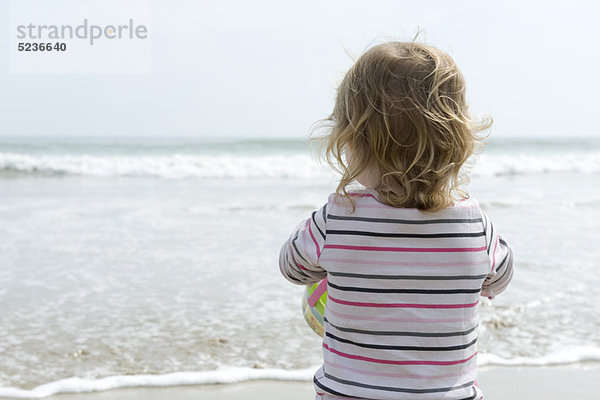 Kleinkind am Strand  Blick aufs Meer  Rückansicht