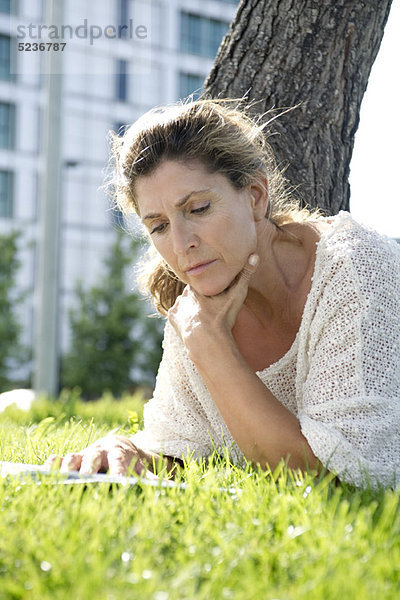 Frau auf Gras liegend Lesebuch