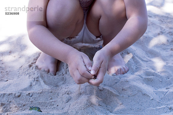 Kleines Mädchen spielt mit Sand  niedrige Sektion