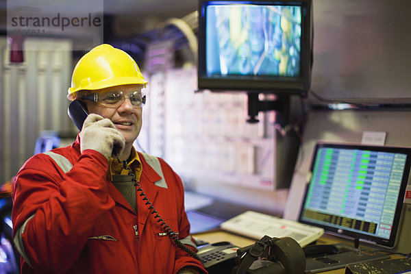 Telefonierender Mitarbeiter im Kontrollraum