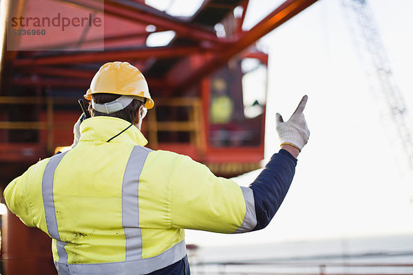 Arbeiter mit Walkie-Talkie auf Bohrinsel