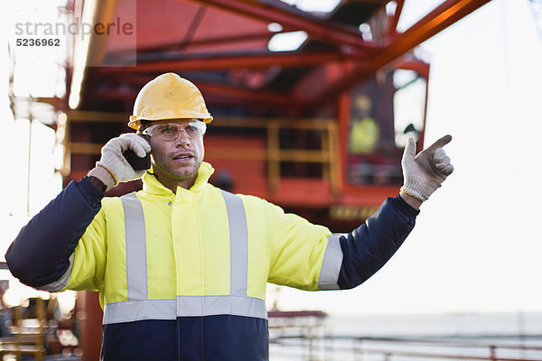 Arbeiter mit Walkie-Talkie auf Bohrinsel