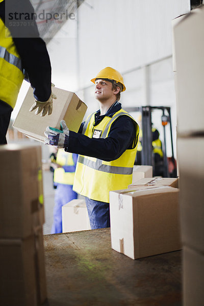 Arbeiter beim Entladen von Kisten vom LKW