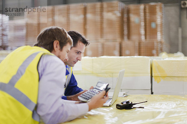 Mitarbeiter mit Laptop im Lager