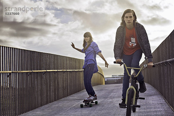 Jugendliche beim Radfahren und Skateboardfahren