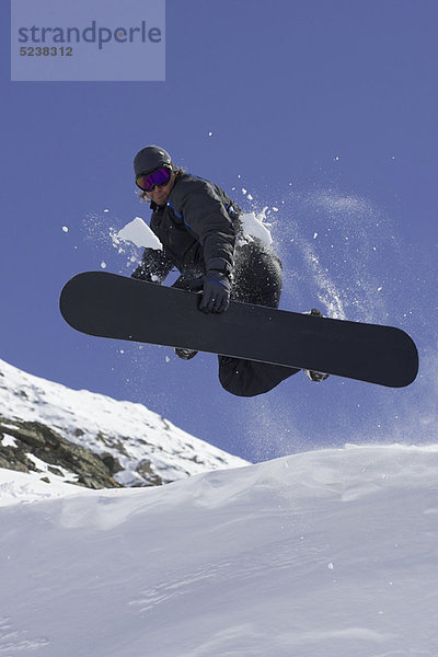 Snowboarder beim Tricksen auf der Piste