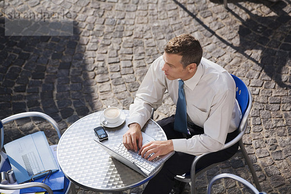 Geschäftsmann mit Laptop im Café