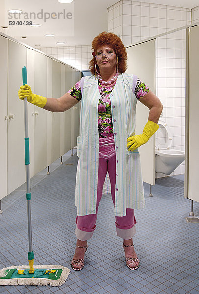 Putzfrau in schriller Aufmachung in Toilettenraum